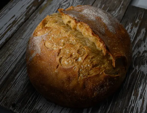 Çürümüş odunların üzerine yerleştirilmiş altın sarısı esmer ekmek sıcak ve sıcak bir atmosferde ev yapımı iyilik yayar..