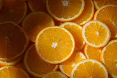 Parlak portakal dilimleri yüzeyi kaplar, güneş ışığını yakalar ve cezbedici taze bir özünü sunar..