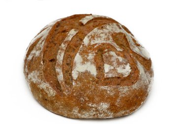 Güzel şekilli yuvarlak bir somun kabuklu dış ve zanaatkar çizgilerini sergileyen beyaz bir yüzeyde duruyor..