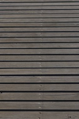 Sakin bir gölün kenarına uzanan yıpranmış ahşap tahtalardan yapılmış sakin bir patika akşam gökyüzünde batan güneşin renklerini yansıtıyor..