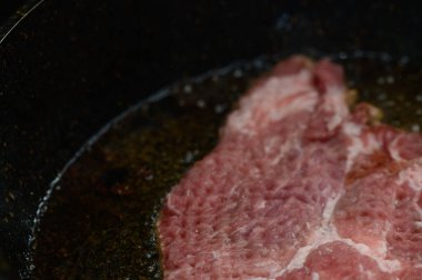 Sıcak yağda kızarmış domuz eti, sıcak bir yemek sırasında mutfağı ağız sulandıran aromalarla dolduruyor..