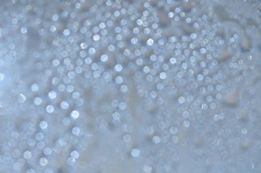 Güneş ışığı damlacıkların arasından süzülür, rüya gibi bir parıltı yayar ve bir yüzeyi göz kamaştırıcı bir ekrana dönüştürür..