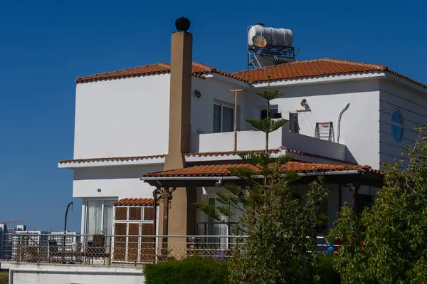 Güzel bir sahil villası güneşe karşı dimdik duruyor, terracotta çatısı ve yemyeşil bir manzarası var. Davet edilen mimaride bir balkon ve su tankı var. Rahatlamak için mükemmel..