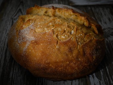 Kıtır kıtır ve yumuşak bir içi olan yuvarlak bir somun altın esmer ekmek dilimlenmeye ve tadını çıkarmaya hazır..