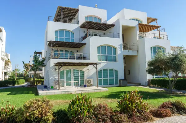 Göz kamaştırıcı beyaz bir bina yemyeşil ve parlak mavi gökyüzüyle çevrili, en güzel kıyı yaşamını sergiliyor..