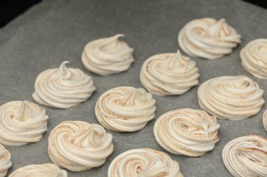 Krema kıvrımları parşömen üzerinde duruyor, sıcak ve davetkar bir mutfak atmosferinde tatlı ikramlara dönüşmeye hazır..