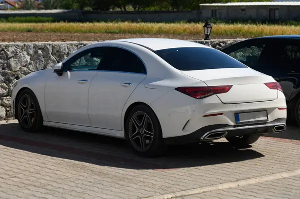 Şık beyaz bir sedan, doğayla çevrili sakin bir yerde zarifçe oturur. Gösterişli çizgileri ve cilalı bitişi, çağdaş cazibesini artıran parlak bir günü yansıtıyor..