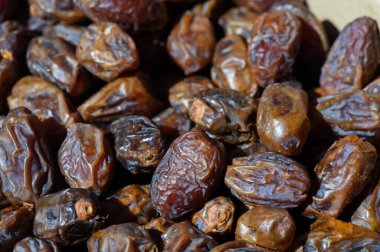 Kurumuş tarihlerden oluşan canlı bir koleksiyon, güneşli öğle saatlerinde kalabalık bir pazarda seyircileri cezbediyor..