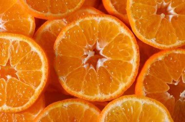 Sulu portakal dilimleri doğal ışık altında zengin renklerini ve tatlılıklarını gösteren bir desen oluşturur..