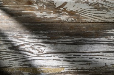 Yumuşak güneş ışığı, eşsiz dokularını ve karmaşık tahıl desenlerini ortaya çıkararak kırsal ahşap bir yüzeyi yıkıyor..