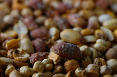 Değişik şekil ve renkleriyle cezbedici ahşap bir yüzeye yayılmış karışık fındıklı canlı bir karışım öğleden sonra atıştırması sırasında görsel bir ziyafet yaratıyor..