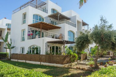 Güneşli bir günde çevresi canlı yeşilliklerle çevrili enfes bir villa..