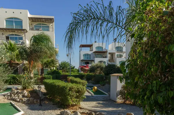 Bereketli yeşillik, güneşli bir günde ziyaretçileri villalara davet etmek için huzurlu bir yol açar..