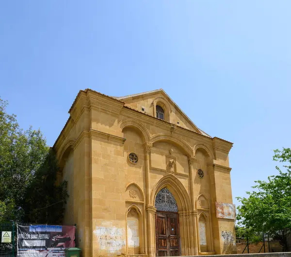 Süslü detayları olan tarihi bir binanın çarpıcı manzarası canlı mavi gökyüzüne doğru yükseliyor. Yeşillik, yapıyı çevreleyerek, olay yerine sükunet ve cazibe katıyor..
