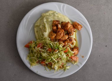 Lezzetli tavuk parçaları, baharatlı ve mükemmel pişirilmiş kadife patates püresi ve taze sebzelerle dolu çıtır bir salata. Öğle yemeğinde doyurucu bir yemek..