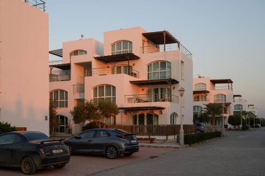 Güneş batarken zarif beyaz villalar gururla kıyıya yakın durur ve sakin bir akşam ortamı yaratır..