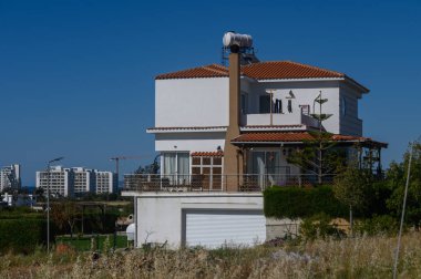 Bu eşsiz konutta beyaz duvarlar ve terracotta çatı karışımı, yemyeşil ve parlak bir gökyüzü altında şehir manzarası ile çevrili çağdaş tasarım sergiler..