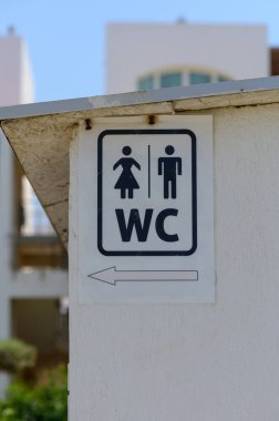 Halka açık bir duvarda basit bir tuvalet tabelası asılıydı. Seyahat, tesis veya kamusal alanla ilgili temalarda pratik kullanım için minimalist tasarım.