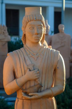 Ziyaretçiler, karanlık çöktüğünde antik sanat eserlerini yansıtan karmaşık bir şekilde işlenmiş terracotta heykellerine hayran kalıyorlar..