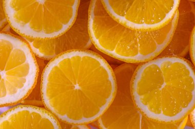 Parlak sarı limon dilimleri, sulu dokularını ve güneşli cazibelerini sergileyerek güzel bir yüzeyde uzanıyordu..