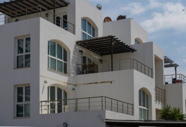 Kıbrıs 'ta deniz manzaralı kıyı yerleşim yerindeki zarif beyaz konutlar.