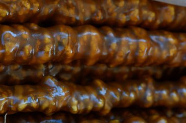 Pekmezle kaplanmış tatlı, yapışkan ikramları yakından izlemek güneşli bir öğleden sonra kalabalık bir pazarda zengin renkler ve dokular sergilemek. Kokular baştan çıkarıcı..