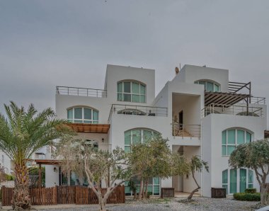 Gösterişli sahil arazisi, parlak çizgiler ve palmiye ağaçları ve kayalık peyzajlarla çevrili doğal elementler içerir..