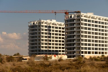 Ufuk çizgisine karşı yükselen iki yeni apartman kompleksi, kentsel gelişim ve inşaat sürecini gözler önüne seriyor.