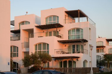 Zarif villalar günbatımının sıcak tonlarını yakalar, yumuşak bir esintiyle sakin bir sahil atmosferi yaratır..