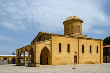 Kadim bir taş kilise görkemli bir şekilde duruyor. Kubbesi gün ortası güneşi altında parıldıyor. Etrafını saran sakin bir köy, başlarının üzerinde hafif bulutlar dolaşıyor..