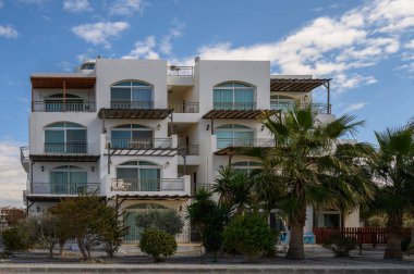 Geniş balkonları ve açık mavi gökyüzünün altında güneşlenen palmiye ağaçları ile çarpıcı bir villa rahatlamaya davetiye çıkarır..