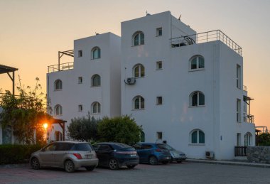 Güneş ışığı, gece çökerken yapıların arasından süzülerek kıyı mimarisinin güzelliğini vurgular..