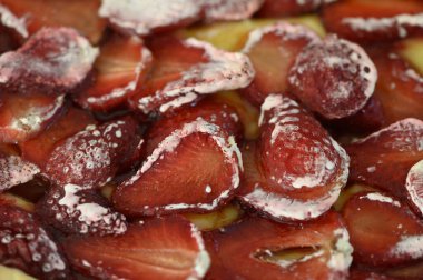 Göz kamaştırıcı bir tatlı sergisi taze, sulu çilekler kremsi bir taban üzerinde sergileniyor, açık hava toplantısı sırasında yazın özünü yakalıyor. Canlı renkler ve dokular hoşgörüyü davet eder..