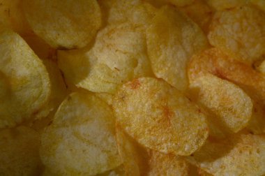 Çıtır patates cipsleri birbirine yakın katmanlı, ışıl ışıl ve lezzetli bir atıştırmalık deneyimi için davet edici..