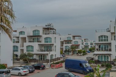 Çağdaş kıyı konutları, bulutlu hava koşulları altında organize yerlere park edilmiş arabalarla gökyüzüne karışıyor..