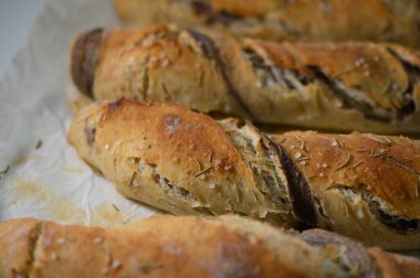 Bu enfes, taze pişmiş zanaatkar ekmekler altın bir kabukla süslenir ve aromatik otlarla serpiştirilir. Sıcak bir mutfak ortamında dayanılmaz bir sıcaklık ve güzel bir koku yayarlar..