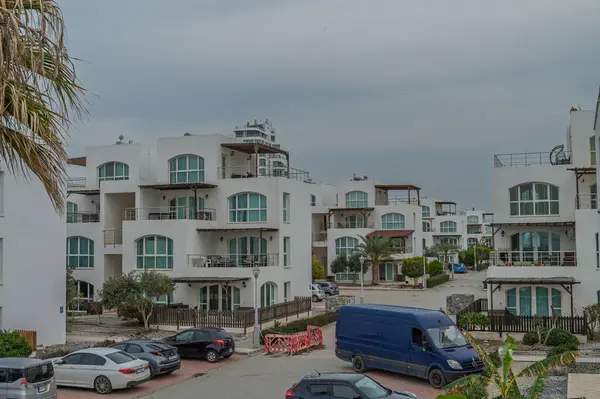 Çağdaş kıyı konutları, bulutlu hava koşulları altında organize yerlere park edilmiş arabalarla gökyüzüne karışıyor..