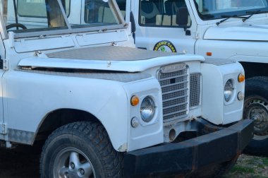 Gaziveren Kıbrıs Rum Kesimi -19.01.2025 Klasik beyaz bir araç yıpranmış bir garajda duruyor, sağlam gövdesi henüz yaşanmamış maceraları ima ediyor.