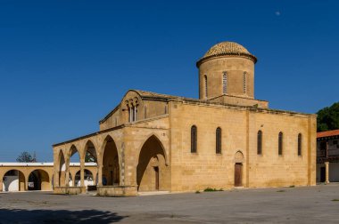 Güzelce işlenmiş bir kilisenin antik taşları güneş ışığında güneşleniyor, sakin köy hayatı ve hareketli bir tarihle çevrili..
