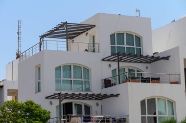 Kıbrıs 'ta denize bakan zarif beyaz villalar. Kırmızı kiremit çatılı klasik Akdeniz tarzında dizayn edilmiş..