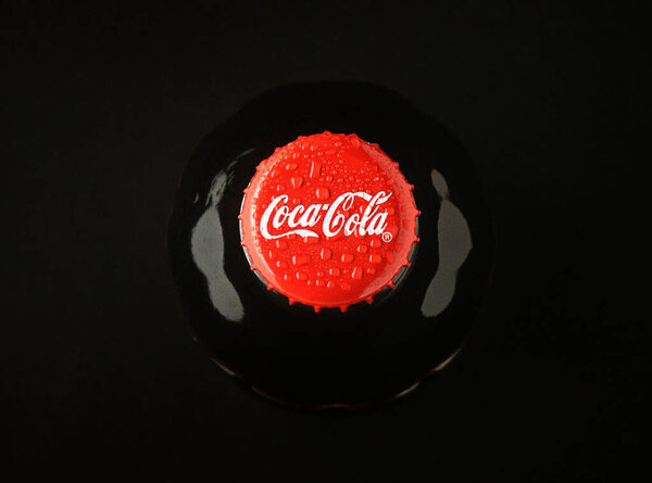 Gaziveren Cyprus -25.02.2025 Droplets of condensation glisten on a vibrant red bottle, showcasing a classic drink at a lively event.