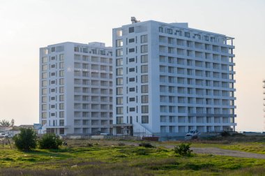 İki çağdaş apartman kulesi, modern kentsel yaşamı yansıtan sakin bir manzaranın ortasında dikiliyor..