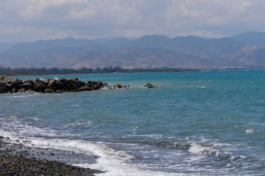 Parlak güneşli huzurlu Akdeniz kıyıları berrak mavi gökyüzü ve kumlu sahili yıkayan sakin deniz dalgaları. İdeal yaz seyahati ve tatil beldesi.