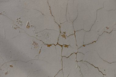 Çatlaklar alçıdan yılan gibi geçiyor, zamanın geçişini gösteriyor, eski, unutulmuş bir yapıda..