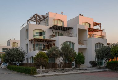 Zarif mimari, yumuşak bir alacakaranlık gökyüzüne karşı duruyor. Mahalleye sükunet ve cazibeyi davet ediyor..