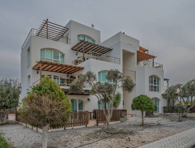 Manikürlü bahçelerdeki zarif villa modern mimariyle ve bulutlu gökyüzünün altında sakin bir atmosferle övünüyor..