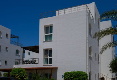 Kıbrıs 'ta denize yakın modern bir kıyı konutu inşa eden şık beyaz evler.