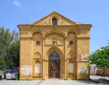 Kuzey Kıbrıs Rum Kesimi 'nin Guzelyurt (Morphou) kentinde bulunan tarihi St. Mamas Manastırı' nın geniş görünümü. Mavi gökyüzünün altında sarı kumtaşı duvarları olan geleneksel Bizans mimarisi.