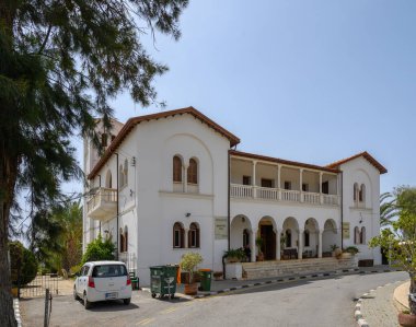 Zarif beyaz villada kemerli pencereler ve yemyeşil ve açık bir gökyüzü ile çevrili bir karşılama verandası yer alıyor. Deniz kıyısındaki bu büyüleyici yeri bir huzur kaplıyor..