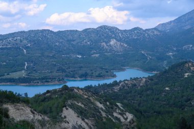 Bereketli yeşil vadiler kayan dağların altına uzanırken sakin bir göl gökyüzünün renklerini yansıtıyor ve bu uzak arazide keşif yapmaya davet ediyor..